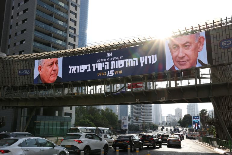 FILE PHOTO: An advert for an Israeli television channel that will broadcast Israel's election coverage features Israeli Prime Minister Benjamin Netanyahu and former Israeli military chief Gadi Eisenkot, leader of the Yashar party, ahead of Israel's national election, on a bridge in Tel Aviv, Israel, October 21, 2026. REUTERS/Ammar Awad/File Photo